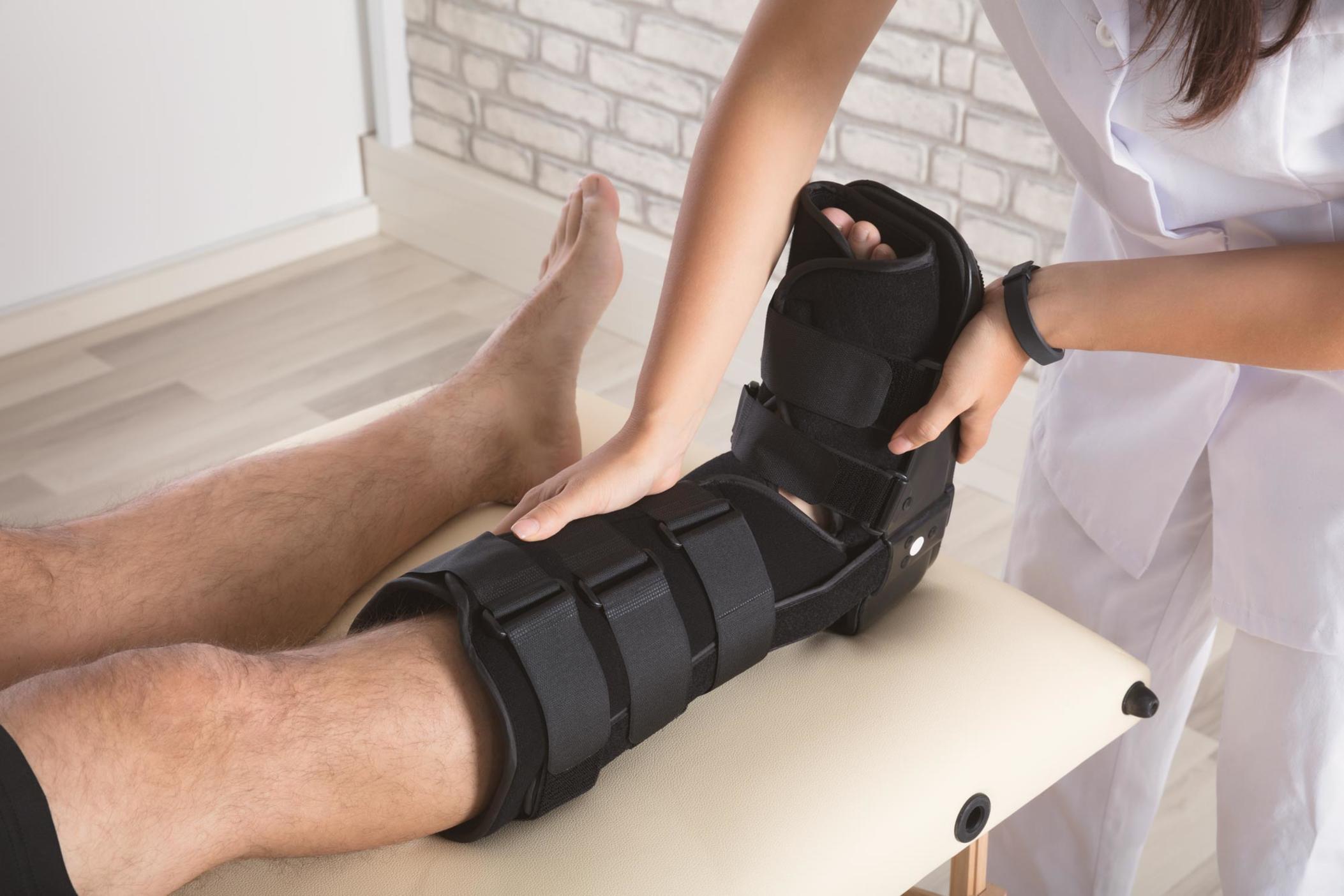 Medical professional adjusting boot cast to leg